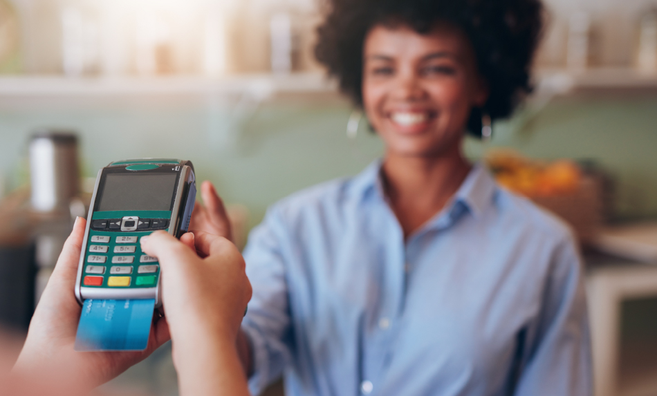 A woman paying by credit card and smiling